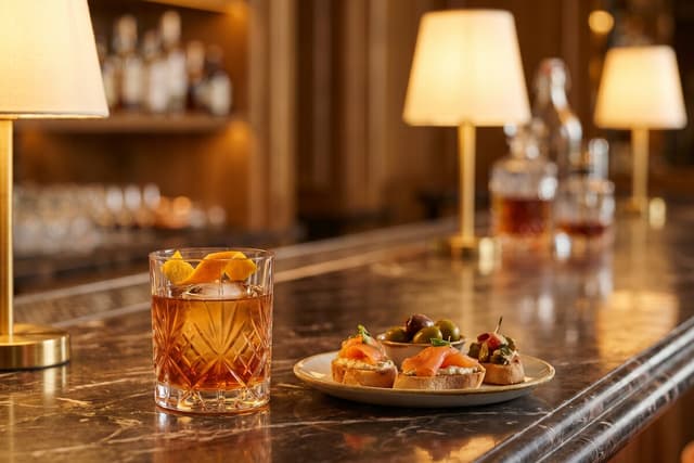 Cocktail and a small plate at a bar